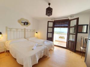 a bedroom with two beds and a large window at La Luna del sur B&B in Granada