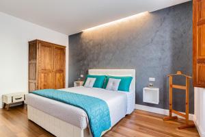 - une chambre avec un grand lit et des oreillers bleus dans l'établissement Marcus Suite, à Cagliari