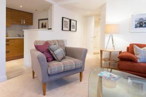 a living room with a chair and a coffee table at The Malt Kiln Apartment Edinburgh Old Town 3 Bedroom Parking previously McDonald Residence in Edinburgh