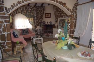 a living room with two tables and a stone wall at Villa la Masia in Miami Platja