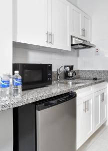 a kitchen with a sink, stove, microwave and dishwasher at R Hotel Kingston in Kingston