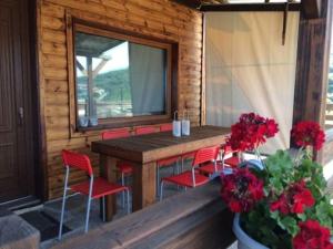 a porch with red chairs and a wooden table with a window at Lotos in Amigdhaleón