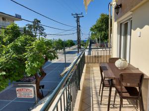 a balcony with a table and chairs and a street at Apartment on main pedestrian street with view in Nea Kalikratia
