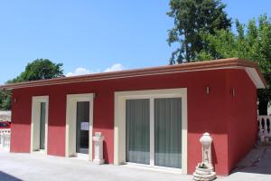 un edificio rojo con puertas correderas de cristal. en Borgo Sole Luna, en Fornelli