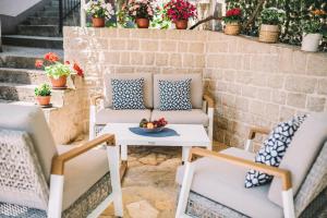 un patio con sillas y una mesa con un bol de fruta en Apartments Villa Egzon, en Ulcinj