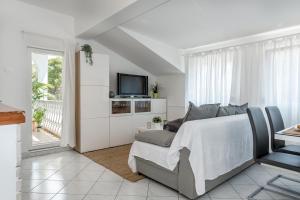 um quarto branco com uma cama e uma televisão em Jadrija Bay em Sibenik