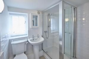 uma casa de banho com um WC, um chuveiro e um lavatório. em Host & Stay - Amber Cottage em Whitby