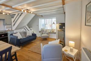 sala de estar con sofá azul y mesa en Host & Stay - Amber Cottage en Whitby