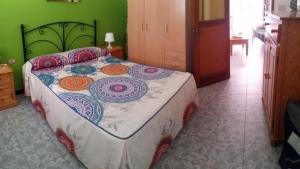 una camera da letto con un grande letto con un copriletto colorato di Casa Mari Playa De Mogan a Puerto de Mogán