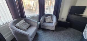 - un salon avec deux chaises et une télévision dans l'établissement St Nicholas Apartments, à Blackpool