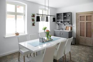 a dining room with a white table and white chairs at Appartement Schloßstraße in Ballenstedt