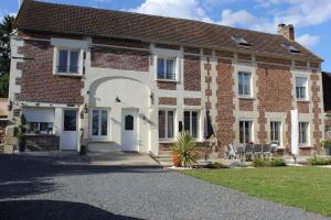 an old brick house with a white door at Le clos du mont César in Bailleul-sur-ThÃ©rain