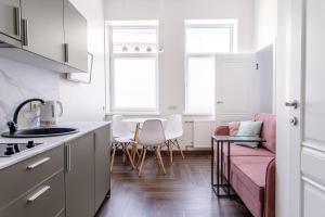 a kitchen with a pink couch and a table at River house apartments in Kaunas