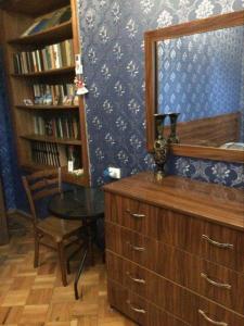 a room with a dresser and a table and a mirror at Guesthouse Raisa in Kvareli