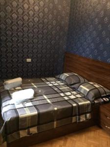 1 dormitorio con 1 cama con pared azul en Guesthouse Raisa, en Kvareli