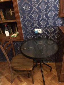 una mesa, una silla, una mesa y una pared en Guesthouse Raisa, en Kvareli