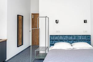 a bedroom with a bed with a blue headboard and a mirror at River house apartments in Kaunas