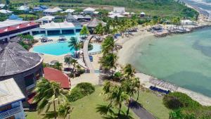 uma vista aérea de um resort com uma piscina e uma praia em Romantisme en Bord de Lagon, Piscine surveillée par un maitre nageur & Plage em Saint-François