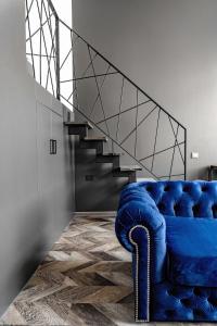 ein blaues Sofa in einem Zimmer mit einer Treppe in der Unterkunft River house apartments in Kaunas