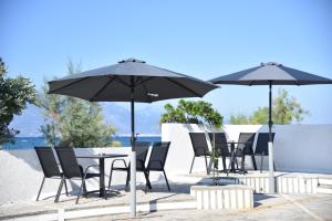 a group of tables and chairs with umbrellas at Family apartments 1 in Lékhaion