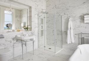 uma casa de banho branca com um chuveiro e um lavatório. em Bathen House Boutique Hotel em Bath