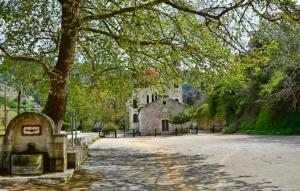 a street with a tree and a stone building at Kleanthi's House in Chania