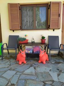 a patio with two orange pig statues in front of a table at Ioannis Stagkonis Apartment in Agios Nikolaos