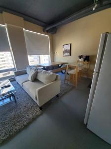 un soggiorno con divano e tavolo di Modern DOWNTOWN Loft Near ROGERS PLACE,SHAW CONF a Edmonton