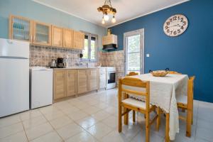 a kitchen with a table with chairs and a refrigerator at Olive Cottage in Astris