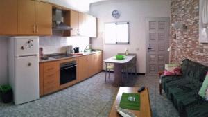 a kitchen with a couch and a refrigerator and a table at Charming Oceanfront House in Puerto de Mogn, Gran Canaria in Puerto de Mogán