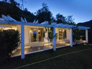 a white house with a pergola at night at Orchidea in Beverino