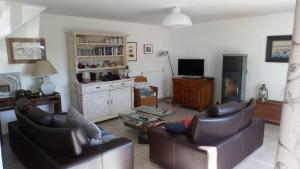 a living room with two leather chairs and a television at Kermaner in Tréveneuc