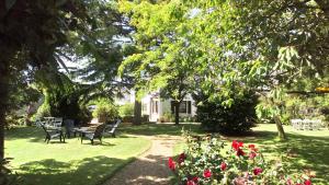 un jardín con mesa, sillas y flores en Kermaner, en Tréveneuc