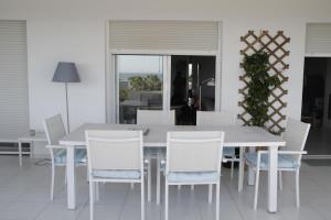 a white dining room table and white chairs at ATICO CON VISTAS AL MAR EN LA AZOHIA in La Azohía