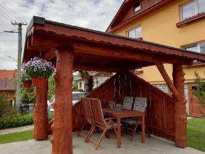 einen hölzernen Pavillon mit einem Tisch und Stühlen in der Unterkunft Privát u Babičky in Ždiar
