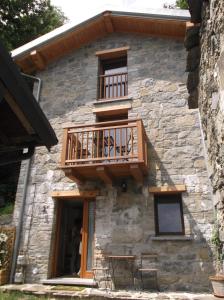 a house with a balcony on the side of it at Agriturismo Ai Ronchi in Sorico