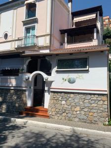 uma casa branca com uma parede de pedra e uma porta em La Casa della Nonna em Scalea