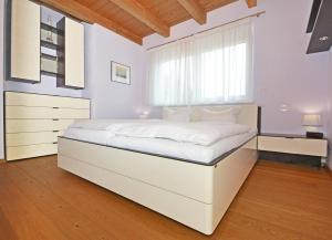 a bedroom with a large white bed with a window at Ferienhaus "Das blaue Haus" mit Kamin und Sauna in Ostseebad Koserow