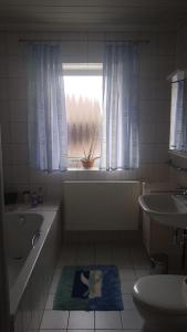 a bathroom with a tub and a sink and a window at Gasthaus Riebel in Kirchendemenreuth