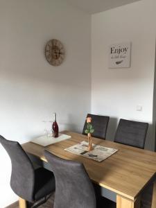 a dining room table with chairs and a clock on the wall at Gasthaus Riebel in Kirchendemenreuth