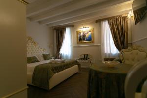 a hotel room with two beds and a table at Ca' Vittoria Apartsuite House Chioggia in Chioggia