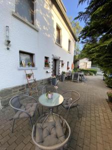 a patio with a table and chairs in front of a building at Fewo Lindenhof in Hatzfeld