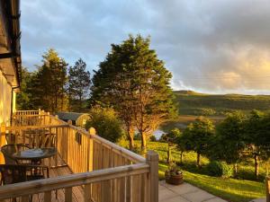 a wooden balcony with a table and chairs on it at Loch Eyre House in Portree