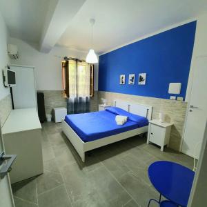 a blue bedroom with a bed and a blue wall at Alba Chiara B&B in San Vito lo Capo