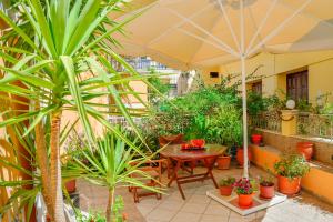 a patio with plants and a table with an umbrella at Villa Mimagia Apartments in Palaiochora