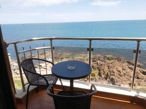 a table and chairs on a balcony overlooking the ocean at Стаи за гости Чайка град Созопол in Sozopol