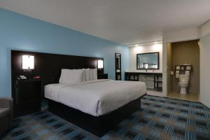 a hotel room with a large bed and a couch at Travelodge by Wyndham Calhoun South I-75 in Calhoun