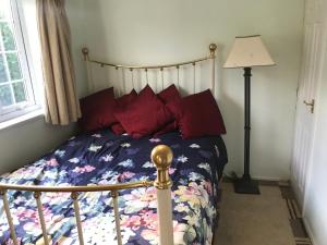 ein Schlafzimmer mit einem Bett mit einer Blumenbettdecke und einer Lampe in der Unterkunft cosy cottage annex in Fairlop in Ilford + 11 Fotos