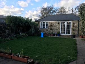 un patio trasero con un objeto azul en la hierba en cosy cottage annex in Fairlop, en Ilford