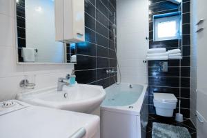 a bathroom with a sink and a toilet and a tub at City Apartments in Trebinje +45 photos